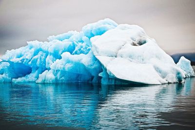 Ice floating on sea against sky during winter