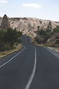 Empty road by mountain against sky