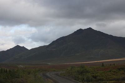 Scenic view of road leading towards mountains against sky