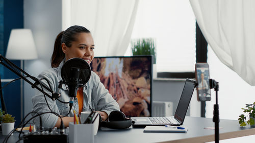 Portrait of young woman using laptop at home