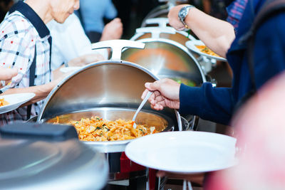 Close-up of people serving food in restaurant