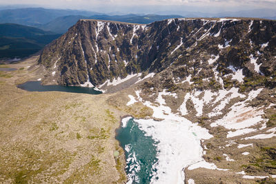 Ultra wide panorama of the horizon. mountains covered with snow, blue lake, glade 