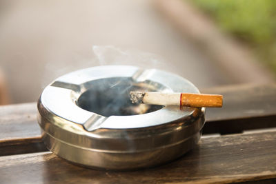 Close-up of cigarette smoking on table