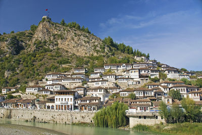 Buildings by town against sky