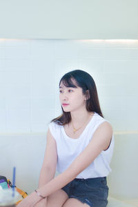 Portrait of young woman sitting on floor at home