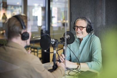 Male radio presenter talking with his guest on radio show or podcast