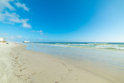 Scenic view of beach against blue sky