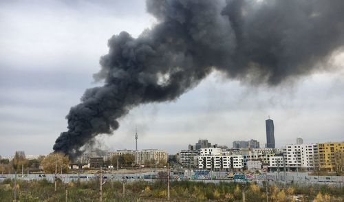 Smoke emitting from factory against sky