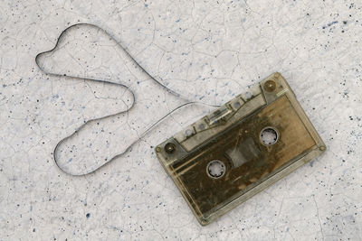 Directly above shot of audio cassette on cracked surface