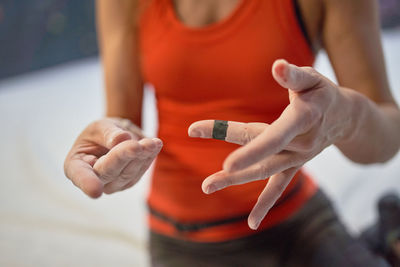 Crop unrecognizable female in sportswear demonstrating hands in chalk and blood after training in bouldering center