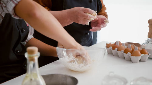 Midsection of people making food against white background