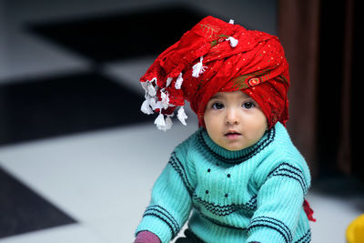 Portrait of cute girl wearing turban sitting at home