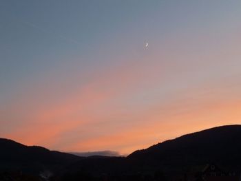 Scenic view of silhouette mountains against sky at sunset