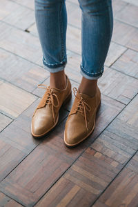 Low section of woman standing on hardwood floor