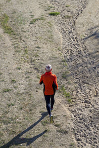 Rear view of senior man running on field