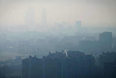 Cityscape against sky during foggy weather