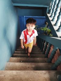 Portrait of cute boy sitting on staircase