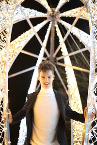 Portrait of smiling young woman standing at amusement park