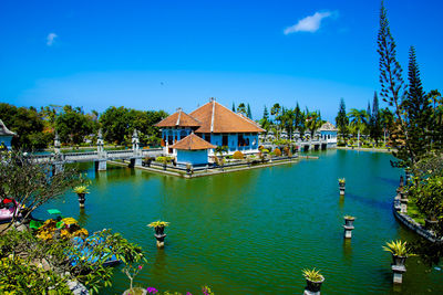 Scenic view of lake by building against blue sky