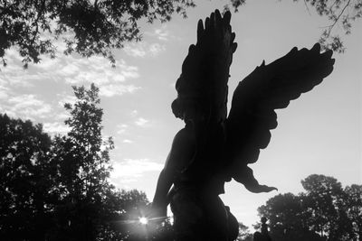 Low angle view of silhouette statue against sky