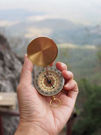 Close-up of hand holding navigational compass