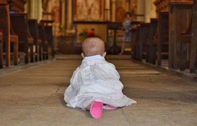 Rear view of boy sitting on floor