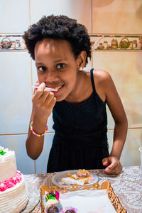 Portrait of girl eating food standing at home