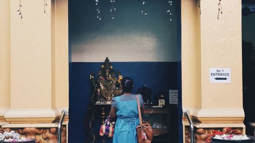 Rear view of man and woman standing at statue