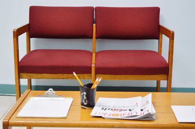 High angle view of papers and desk organizer on table against chairs