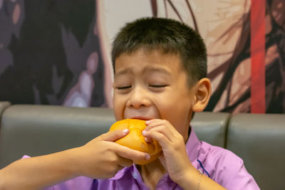 Close-up of boy eating burger