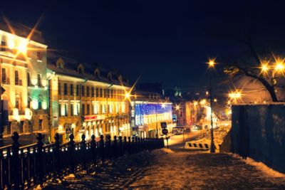 Illuminated city against sky at night