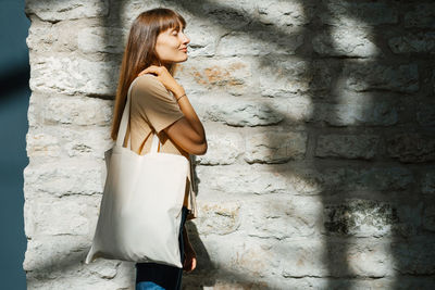 Woman holding white canvas tote bag. bag mockup for design.
