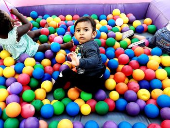 Portrait of cute boy sitting in balls