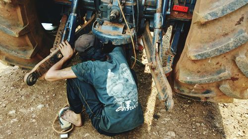 Low section of man working on motorcycle