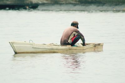 Fisherman sitting in boat at lake