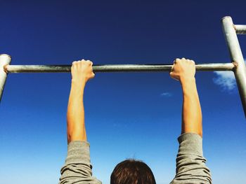Man holding metallic rod against sky