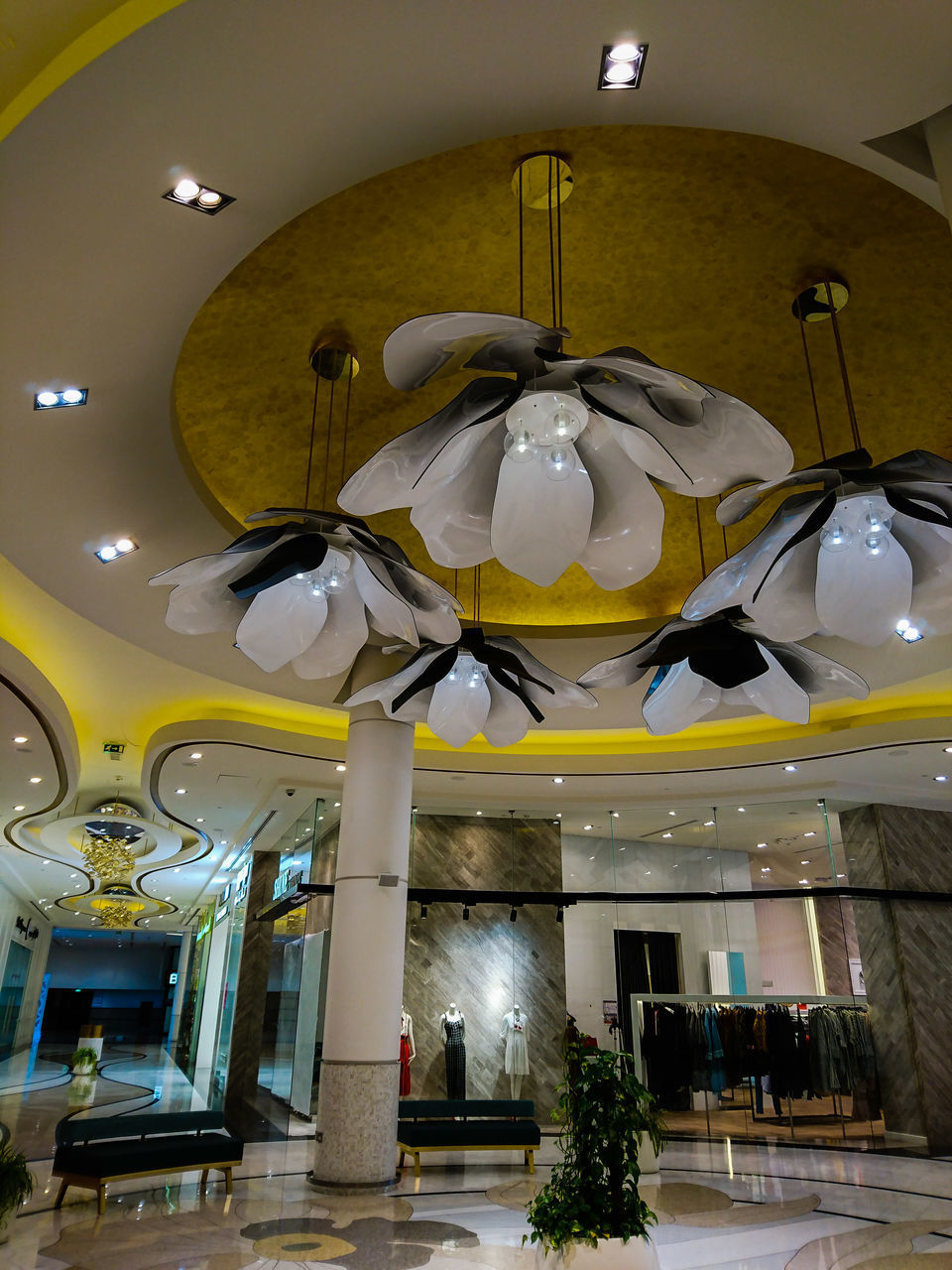 LOW ANGLE VIEW OF ILLUMINATED PENDANT LIGHTS HANGING IN BUILDING