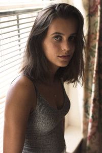 Close-up portrait of young woman standing at home