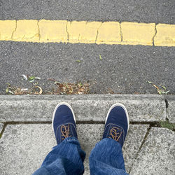 Low section of man standing on sidewalk