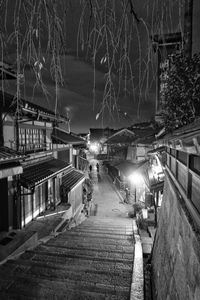 Illuminated street amidst buildings in city at night