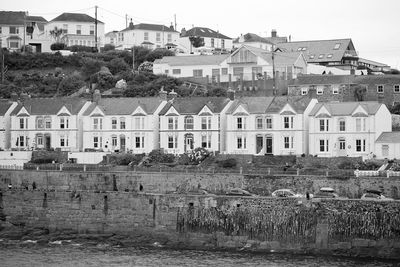 Houses by river in town against sky