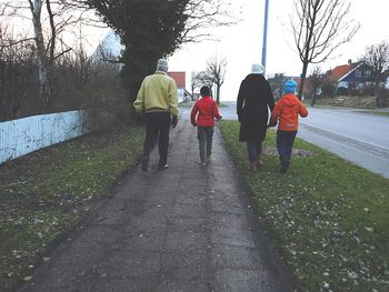 Rear view of woman walking on footpath