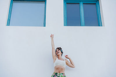 Woman standing against white wall