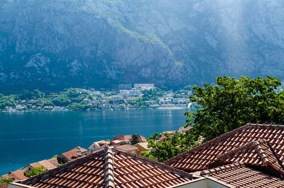 Aerial view to the blue, calm, sea surface, roofs of mediterranean houses and a mountain range