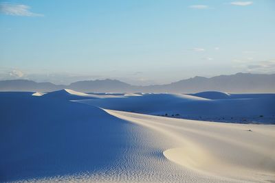 Scenic view of snowcapped mountains against blue sky