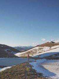 Rear view of woman standing on snow covered landscape