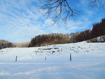 Scenic view of snow covered field against sky