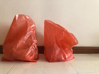 Close-up of red umbrella on tiled floor against wall