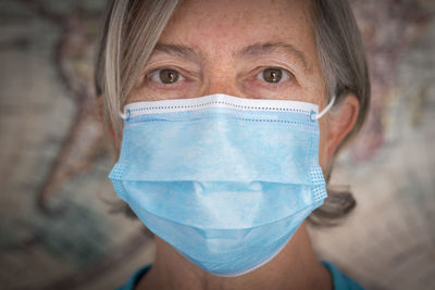 Close-up portrait of senior woman wearing flu mask
