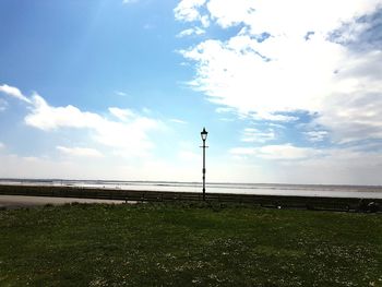 Street light on field against sky